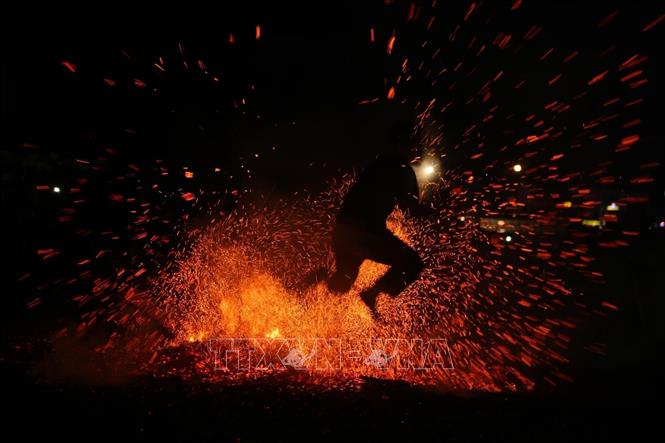 Dancers jump over the burning coals with their bare feet without getting burned. VNA Photo: Quý Trung