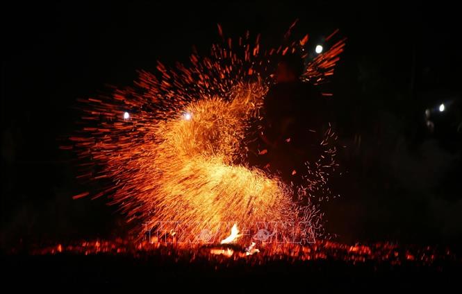 Dancers jump over the burning coals with their bare feet without getting burned. VNA Photo: Quý Trung
