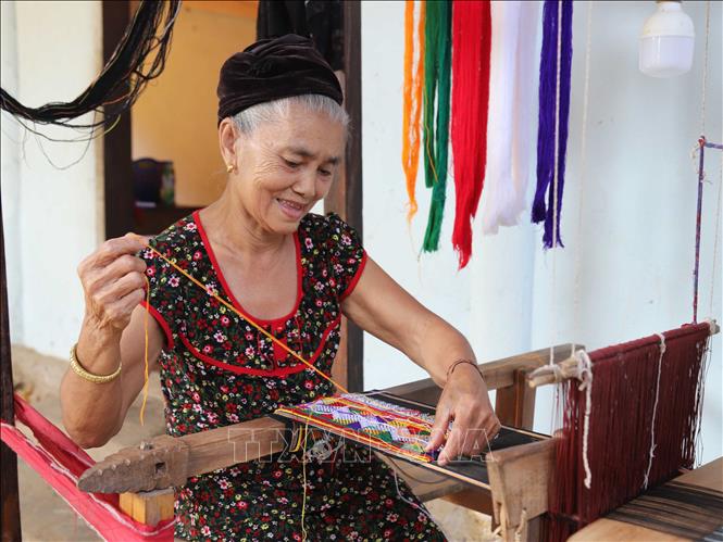 Bà Vi Thị Dung (76 tuổi) ở bản Văng Môn, xã Nga My (Tương Dương, Nghệ An) dệt vải, tạo hoa văn, họa tiết cho chân váy truyền thống của dân tộc Ơ Đu. Ảnh: Xuân Tiến - TTXVN  
