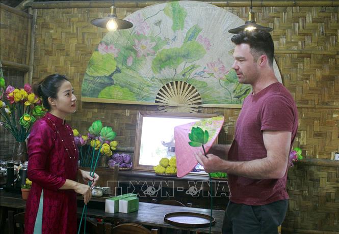 Giới thiệu các sản phẩm được làm từ sen với du khách quốc tế. Ảnh: Thùy Dung - TTXVN