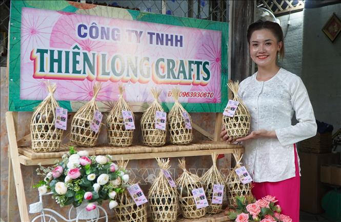 Chị Nguyễn Thị Thơ với sản phẩm ốc gác bếp. Ảnh: Nhựt An - TTXVN