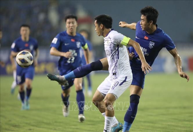 Pha tranh cướp bóng giữa đội trưởng Văn Quyết (số 10, Hà Nội) và cầu thủ bên phía Wuhan Three Towns. Ảnh: Minh Quyết - TTXVN