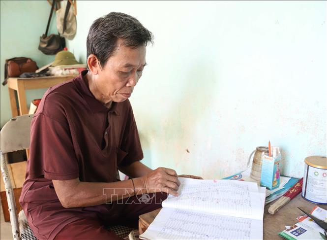 Nhiều năm qua, ông Lo Thanh Bình vẫn dành thời gian nghiên cứu tài liệu, giáo án để củng cố, bổ sung vốn từ vựng và luyện đọc cách phát âm tiếng nói, ngôn ngữ dân tộc Ơ Đu. Ảnh: Xuân Tiến - TTXVN 