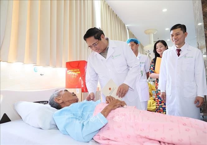Thủ tướng Phạm Minh Chính thăm bệnh nhân đang điều trị tại Bệnh viện đa khoa Quốc tế Hợp Lực. Ảnh: Dương Giang-TTXVN
