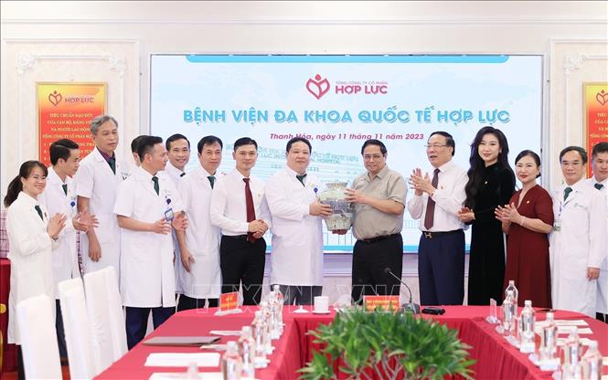 Thủ tướng Phạm Minh Chính tặng quà lưu niệm cho Bệnh viện đa khoa Quốc tế Hợp Lực. Ảnh: Dương Giang-TTXVN
