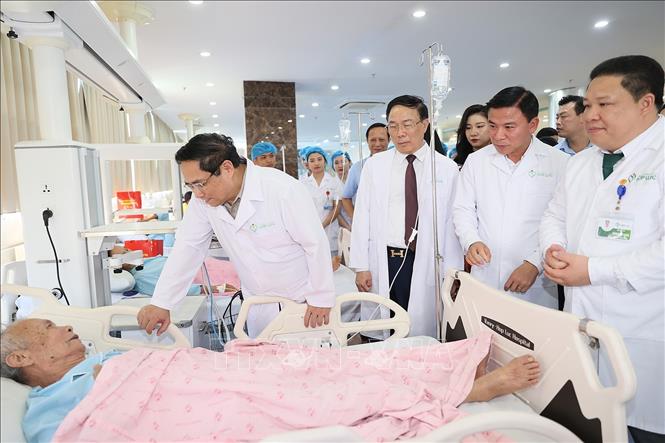 Thủ tướng Phạm Minh Chính thăm bệnh nhân đang điều trị tại Bệnh viện đa khoa Quốc tế Hợp Lực. Ảnh: Dương Giang-TTXVN
