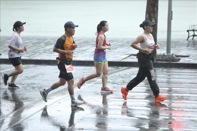 Mặc dù trời mưa, các VĐV nỗ lực hoàn thành phần thi của mình. Ảnh: Minh Quyết - TTXVN