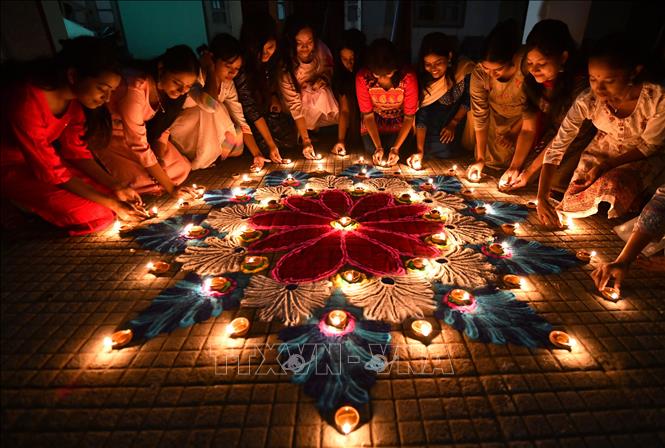 Một nhóm sinh viên thắp sáng những ngọn đèn dầu nhân lễ hội ánh sáng Diwali ở Guwahati, Ấn Độ ngày 12/11/2023. Ảnh: AFP/TTXVN