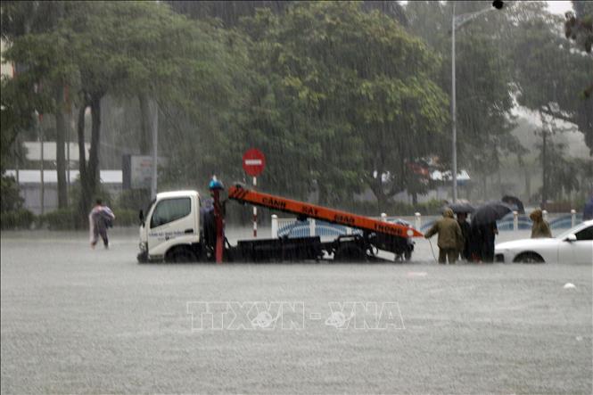 Xe cứu hộ hỗ trợ xe ô tô con ra khỏi vị trí bị ngập sâu. Ảnh: Đỗ Trưởng - TTXVN

