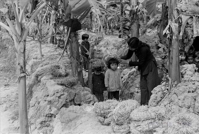Cô giáo tập cho các cháu đội mũ rơm, chạy ra hầm khi máy bay địch bắn phá (1967). Ảnh: Phan Huy - TTXVN