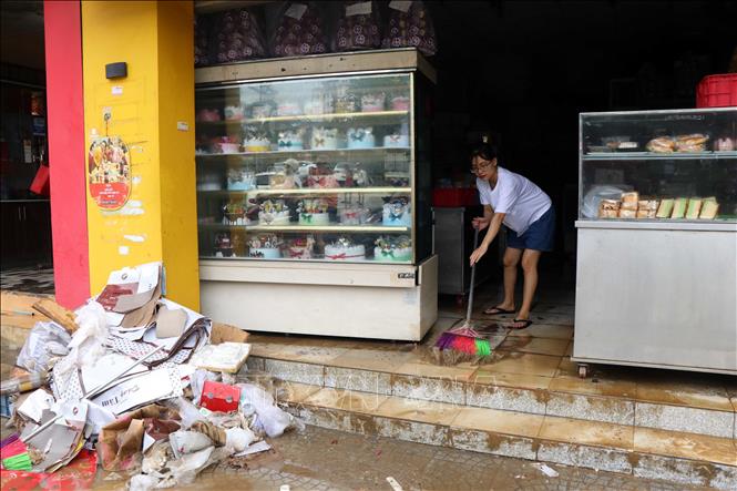 Người dân buôn bán trên đường Bà Triệu, thành phố Huế, dọn dẹp vệ sinh sau khi nước lũ rút. Ảnh: Đỗ Trưởng - TTXVN