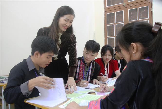Cô giáo Nguyễn Thị Mai hướng dẫn học sinh làm bài tập thực hành. Ảnh: Phan Quân - TTXVN