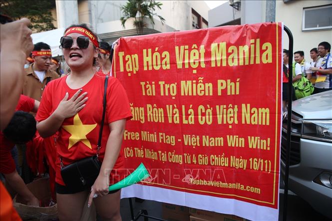 Chị Thảo Linh, chủ cửa hàng tạp hoá Việt Nam ở Philippines, tài trợ miễn phí nước uống và băng rôn cổ động cho CĐV Việt Nam. Ảnh: Hoàng Linh/TTXVN