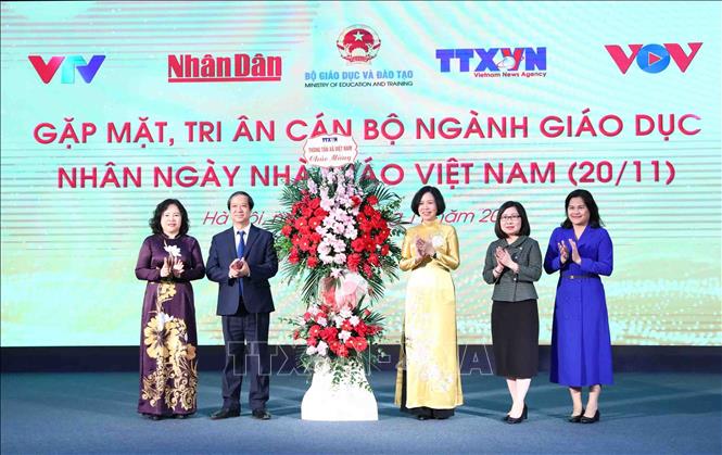 Tổng Giám đốc Vũ Việt Trang thay mặt cán bộ, phóng viên, biên tập viên TTXVN tặng hoa chúc mừng Bộ trưởng Bộ Giáo dục và Đào tạo Nguyễn Kim Sơn cùng toàn thể cán bộ, các thầy cô giáo nhân Ngày Nhà giáo Việt Nam. Ảnh: Minh Đức - TTXVN


