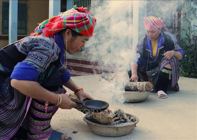 Chị Lý Thị Ninh và thành viên hợp tác Thổ cẩm xã Chế Cu Nha, huyện Mù Cang Chải chuẩn bị lửa đun sáp ong. Ảnh: Tuấn Anh - TTXVN