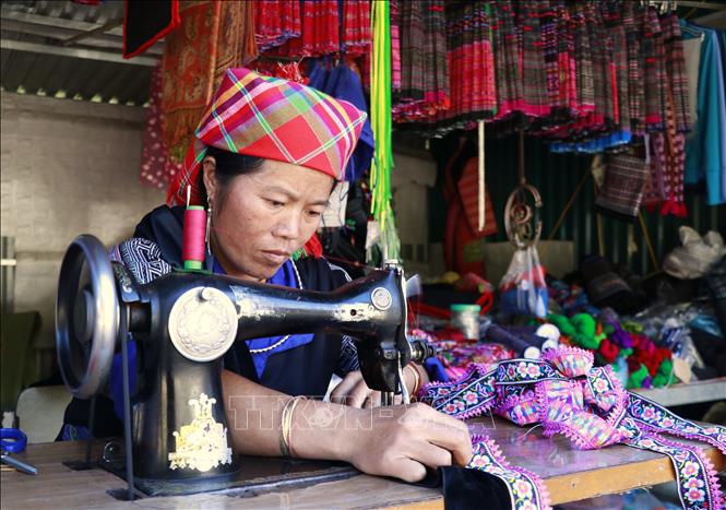 Công đoạn ghép các mảnh vải vẽ sáp ong thành các bộ phận như: vai áo, thân váy hay tay áo, cổ áo, địu, khăn rồi khâu lại thành sản phẩm hoàn chỉnh. Ảnh: Tuấn Anh - TTXVN