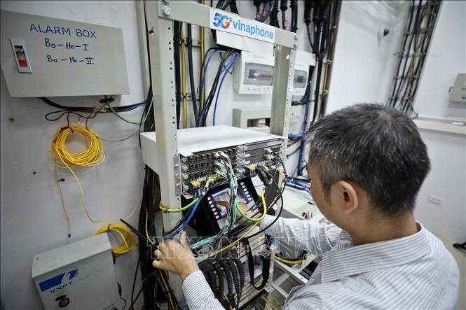 Nhân viên kỹ thuật VNPT kiểm tra truyền dẫn quang và đo sóng đứng tại trạm 5G của Vinaphone. Ảnh: Minh Quyết - TTXVN