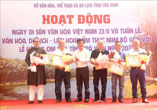 Phó Giám đốc Sở Văn hoá, Thể thao và Du lịch tỉnh Trà Vinh Lâm Hữu Phúc tặng Giấy khen cho các cá nhân có nhiều đóng góp trong việc trao tặng các hiện vật. Ảnh: Thanh Hoà- TTXVN 