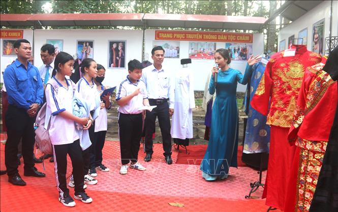 Các đại biểu và học sinh tìm hiểu trang phục truyền thống các dân tộc ở Trà Vinh. Ảnh: Thanh Hoà- TTXVN