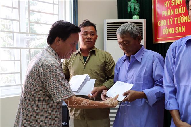 Phó Chủ tịch UBND thị xã Hoài Nhơn (tỉnh Bình Định) Nguyễn Chí Công trao quà cho ngư dân. Ảnh: Đoàn Mạnh Dương - TTXVN