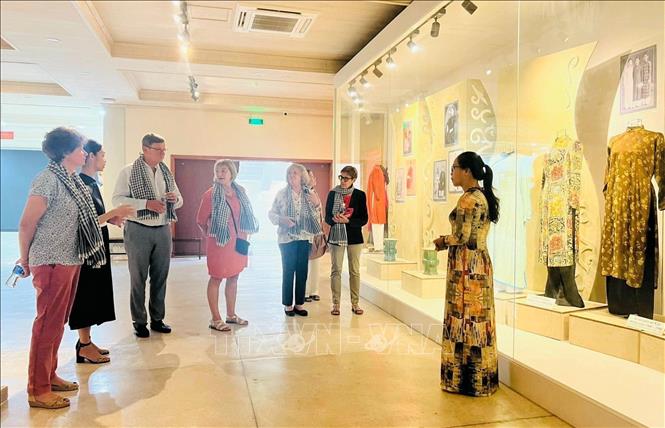 Khách tham quan nghe thuyết minh tại phòng trưng bày áo dài của Bảo tàng Phụ nữ Nam bộ (Quận 3). Ảnh: Thu Hương - TTXVN