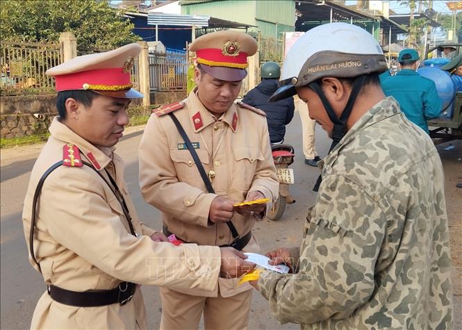 Cảnh sát giao thông Đắk Nông phát đề can phản quang cho các chủ xe công nông. Ảnh: TTXVN phát