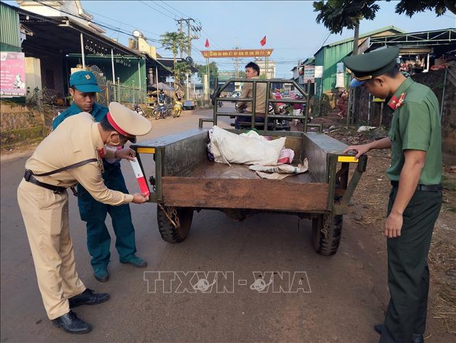 Lực lượng công an, dân quân dán đề can phản quang cho xe công nông. Ảnh: TTXVN phát