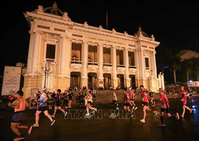 Các VĐV thi đấu cự ly 42 km chạy qua khu vực Quảng trường Cách mạng Tháng Tám. Ảnh: Hoàng Hiếu - TTXVN