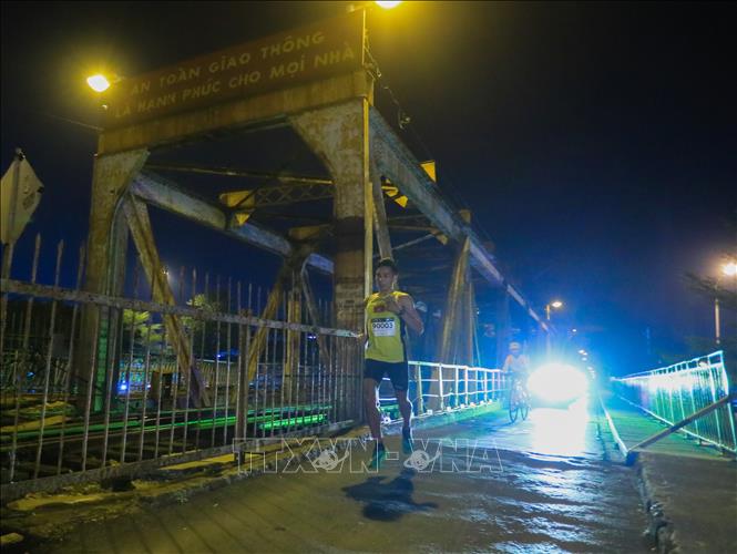 VĐV Nguyễn Văn Lai chạy trên cầu Long Biên lúc 2h20' - bỏ xa các VĐV còn lại ở cự ly 42 km. Ảnh: Hoàng Hiếu - TTXVN