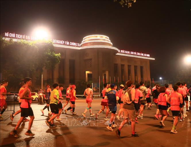 Các VĐV thi đấu cự ly 42 km chạy qua phía trước trụ sở Ngân hàng Nhà nước. Ảnh: Hoàng Hiếu - TTXVN