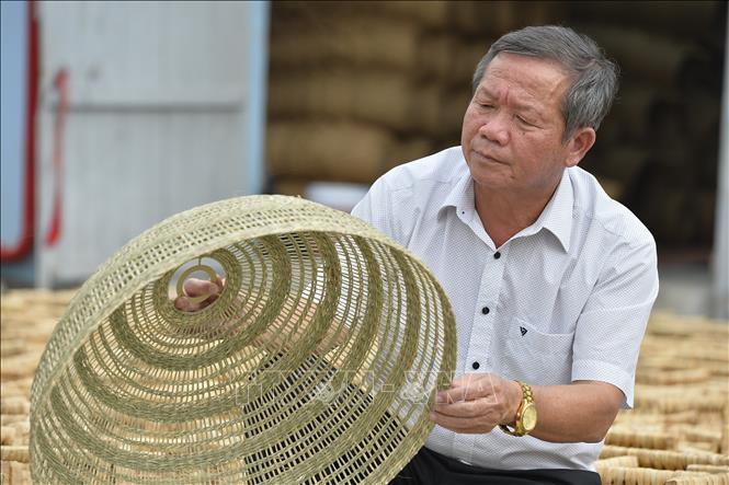 Giáo dân Phạm Đăng Khuyến, Giám đốc Công ty TNHH Xuất khẩu và Đầu tư Thành Hóa kiểm tra sản phẩm của công ty. Ảnh: Minh Đức - TTXVN

