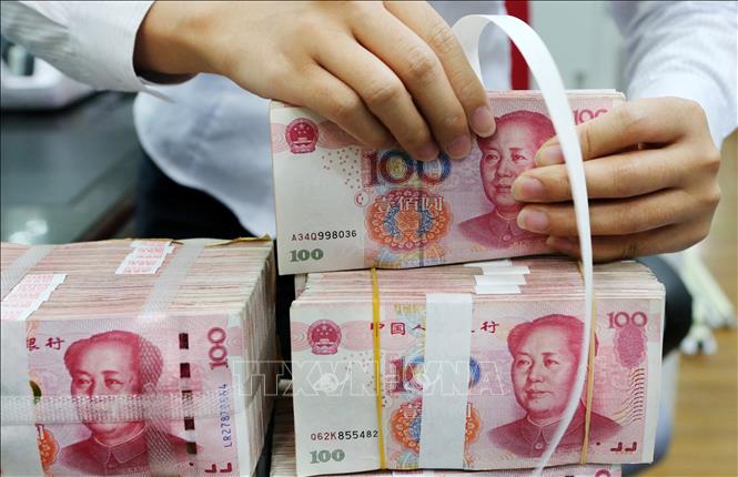 Đồng tiền mệnh giá 100 nhân dân tệ tại ngân hàng ở tỉnh Giang Tô, Trung Quốc. Ảnh: AFP/TTXVN