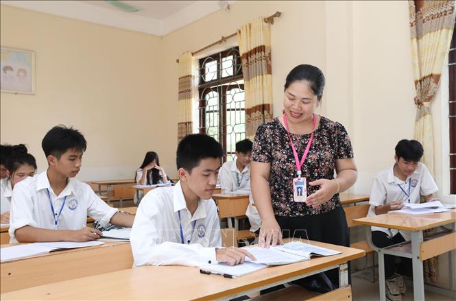 Đảng viên, giáo viên Hoàng Thị Thu Hằng hướng dẫn học sinh Lớp 10A2, Trường THPT Đình Lập môn Ngữ văn. Ảnh: Anh Tuấn - TTXVN  