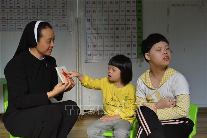 Các nữ tu chăm sóc trẻ em khuyết tật, tự kỷ tại cơ sở. Ảnh: Minh Đức - TTXVN

