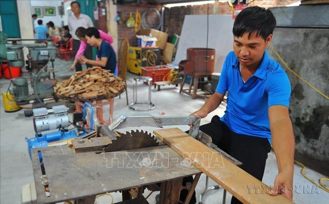 Người khuyết tật làm đồ gỗ tại trung tâm dạy nghề phát triển việc làm và hỗ trợ người khuyết tật cơ sở 2 tại huyện Yên Khánh (Ninh Bình). Ảnh: Minh Đức - TTXVN
