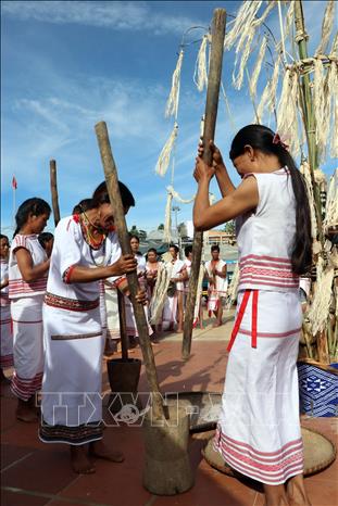 Ro Mam girls bray rice grains after the barn opening ceremony. VNA Photo: Cao Nguyên