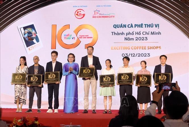 Bà Bùi Thị Ngọc Hiếu, Phó Giám đốc Sở Du lịch Thành phố Hồ Chí Minh trao bảng vàng công nhận cho 10quán cà phê thú vị. Ảnh: Thu Hương - TTXVN