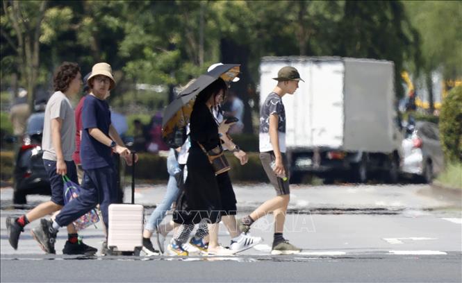Người dân di chuyển trên đường phố dưới trời nắng nóng tại Tokyo, Nhật Bản. Ảnh: Kyodo/TTXVN