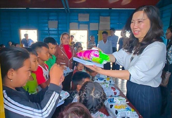 Deputy Foreign Minister Le Thi Thu Hang presents gifts to Vietnamese-origin children in Kbal Tao floating village in Koh Chiveang commune, Ek Phnom district, Battambang province, Cambodia. VNA Photo