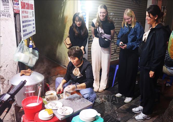 Du khách xem làm bánh cuốn nóng trên phố Hàng Điếu. Ảnh: Vũ Thanh - TTXVN phát