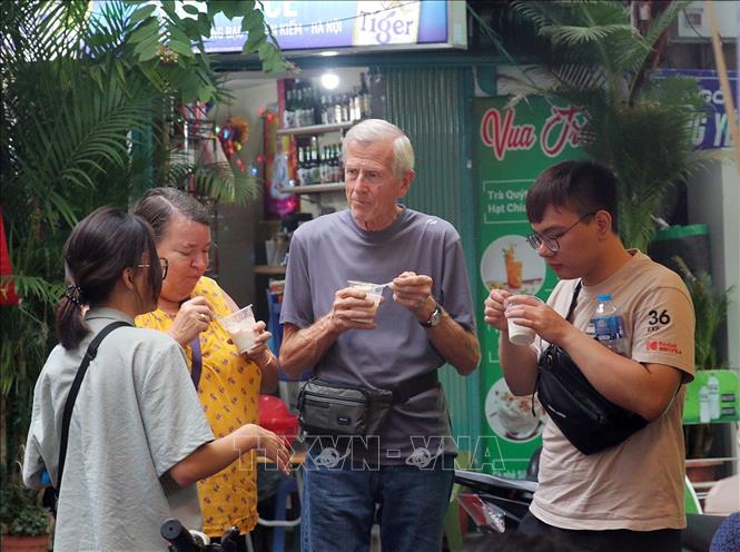 Du khách thưởng thức món sữa chua mít, món ăn hấp dẫn chỉ với khoảng 20 nghìn đồng/cốc. Ảnh: Vũ Thanh - TTXVN phát