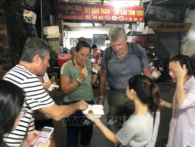 Du khách thưởng thức ẩm thực trên phố Đào Duy Từ. Ảnh: Mai Hiền - TTXVN phát 
