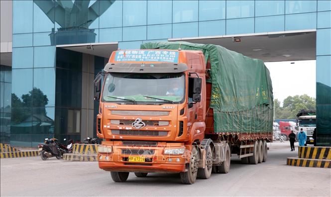 Phương tiện chở hàng hóa thông quan qua cửa khẩu Móng Cái (Việt Nam)- Đông Hưng (Trung Quốc) tại khu vực cầu Bắc Luân II. Ảnh: Văn Đức - TTXVN
