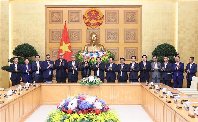 Thủ tướng Phạm Minh Chính và ông Jensen Huang Chủ tịch kiêm Giám đốc điều hành Tập đoàn NVIDIA cùng các thành viên đoàn chụp ảnh chung. Ảnh: Dương Giang-TTXVN
