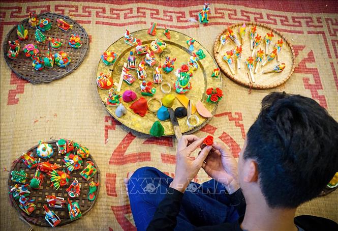 Artisan make figurines on-demand for young customers, demonstrating their skills and experience. VNA Photo: Khánh Hòa