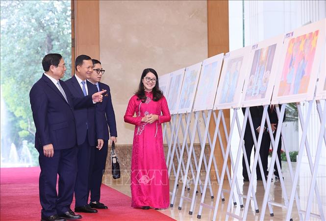 Thủ tướng Phạm Minh Chính và Thủ tướng Campuchia Samdech Hun Manet tham quan trưng bày ảnh. Ảnh: Dương Giang-TTXVN
