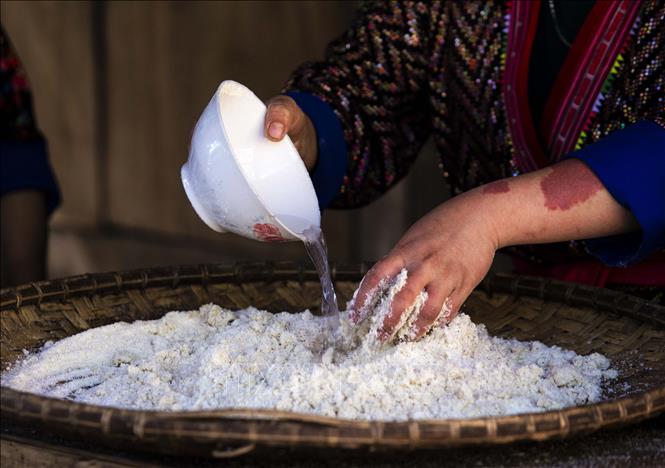 Bột ngô sau khi xay xong được trộn nước ủ cho bột ngấm nước. Ảnh: Xuân Tư – TTXVN