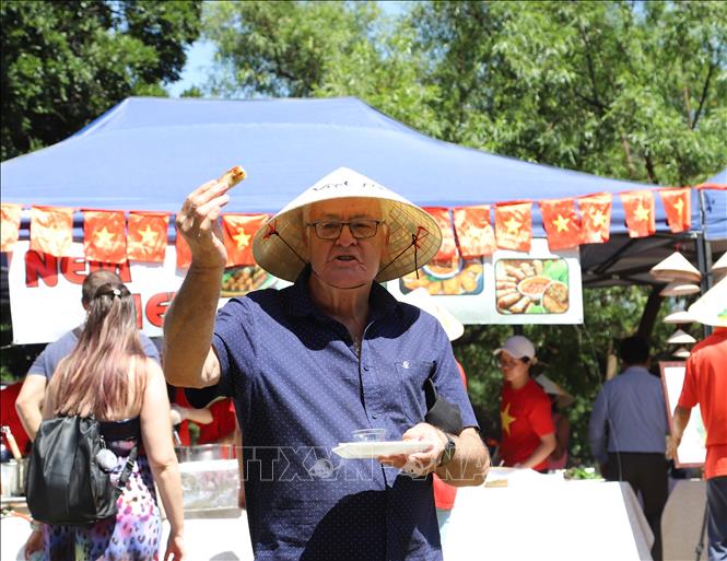 Cụ Stoffel van Zyl, người Nam Phi vui mừng vì được thưởng thức món ăn Việt Nam, được đội chiếc nón lá Việt Nam mà trước đây hai cụ chỉ có thể được biết qua sách báo, tranh ảnh và Youtube. Ảnh: Hồng Minh - P/v TTXVN tại Pretoria, Nam Phi