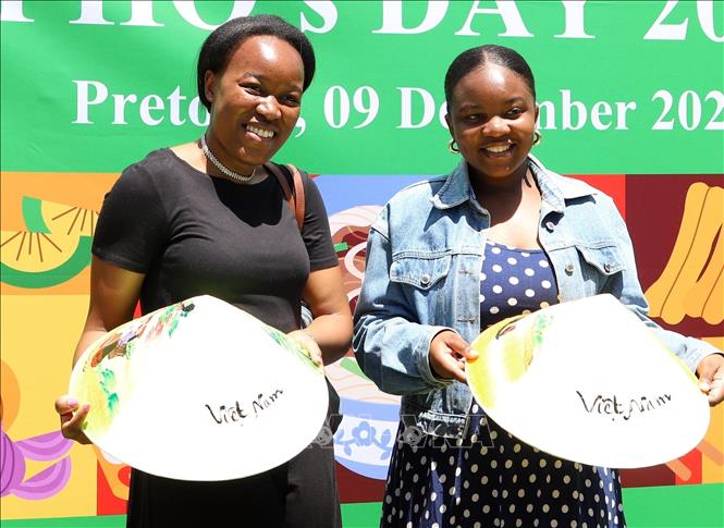 Hai người bạn Nam Phi thích thú chụp ảnh lưu niệm cùng nón lá Việt Nam tại sự kiện Ngày Phở Việt Nam tại Nam Phi 2023. Ảnh: Hồng Minh - P/v TTXVN tại Pretoria, Nam Phi