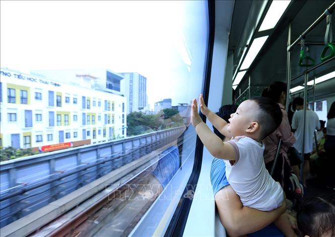 Trẻ em thích thú khi được đi cùng bố mẹ trên tàu điện tuyến đường sắt đô thị Cát Linh - Hà Đông, loại hình giao thông xanh đang từng bước phát triển ở Thủ đô. Ảnh: Tuấn Anh - TTXVN